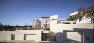 a white building with two garage doors on it at Somewhere - Estoril Guesthouse in Estoril