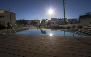 a large swimming pool in a city at night at Somewhere - Estoril Guesthouse in Estoril