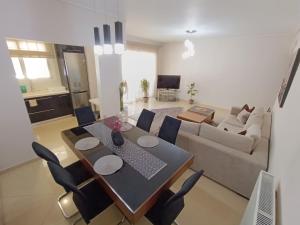 a living room with a table and a couch at NEW elegant roof apartment in Acharnes