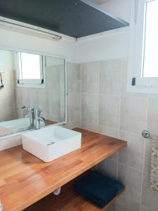 a bathroom with a white sink and a mirror at Le Caro - pieds dans l'eau - clim - wifi in Saint-Gilles-les-Bains