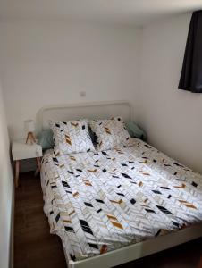 ein Schlafzimmer mit einem Bett mit einer weißen Bettdecke in der Unterkunft Appartement Cosy avec extérieur in Saint-Privat-des-Vieux
