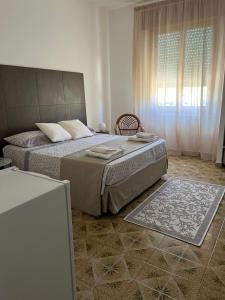 a bedroom with a large bed and a window at Villa Zagara in Marsala
