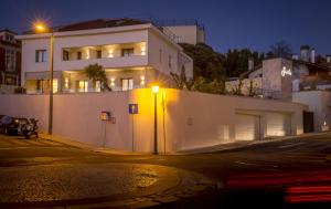 a white building on a street at night at Somewhere - Estoril Guesthouse in Estoril