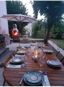 - une table en bois avec des assiettes et des verres à vin dans l'établissement Casa i Quattro Alberi, à Montemiletto