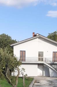 Cette maison blanche dispose d'un balcon. dans l'établissement Casa i Quattro Alberi, à Montemiletto
