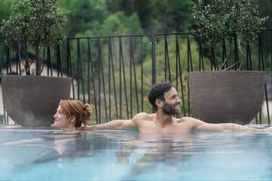 Ein Mann und eine Frau schwimmen im Whirlpool in der Unterkunft Refugium Lunz in Lunz am See