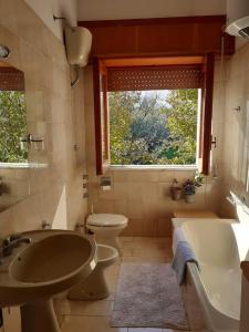 La salle de bains est pourvue d'une baignoire, d'un lavabo et de toilettes. dans l'établissement Casa i Quattro Alberi, à Montemiletto