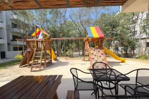 a playground with a slide and a slideintend at Departamento de Lujo en Playa in Playa del Carmen