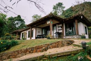 uma pequena casa com uma parede de pedra em frente em Eucaliptus Spa Resort em Dapa
