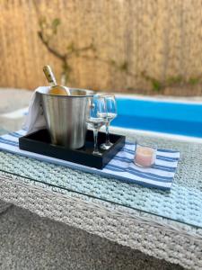 a tray with a pot and wine glasses on a table at Holiday Oasis with private patio and Hammam-style bath in Chora-Pithagoreo, Samos Island in Chóra