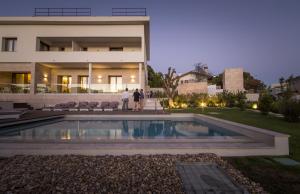 a house with a swimming pool in front of a building at Somewhere - Estoril Guesthouse in Estoril