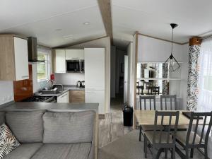 a kitchen and living room with a table and chairs at Lean into the Gardens of Heligan in St Austell
