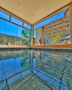 uma piscina interior com vista para um edifício em Hotel Zanon em Águas de Lindóia