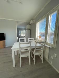 a dining room with a white table and chairs at Serenity Cottage 2 in Närpiö