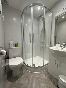 a bathroom with a shower and a toilet and a sink at Shipping Lanes Hotel in Morecambe +65 photos