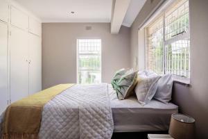 um quarto com uma cama com almofadas em The Hide Out - Home away from home em Joanesburgo