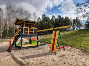 einen Spielplatz mit zwei Spielgeräten auf einem Feld in der Unterkunft Drewniany Domek w Zakątku Andrzeje Śniczany 18 in Sniczany