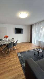 ein Wohnzimmer mit Tisch und Stühlen und einem Fernseher in der Unterkunft Casa Estella in Rust