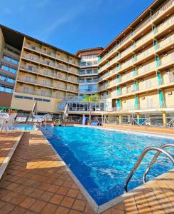 a swimming pool in front of a large building at Hotel Zanon in Águas de Lindóia