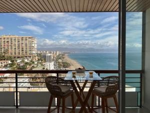 d'une table et de chaises sur un balcon avec vue sur l'océan. dans l'établissement Carré D OR au santa Clara torremolinos, à Torremolinos