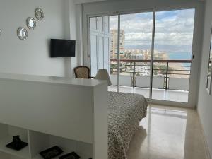 - une chambre avec un lit et un balcon avec vue dans l'établissement Carré D OR au santa Clara torremolinos, à Torremolinos