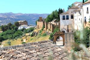 uma vista para uma aldeia com edifícios numa colina em Typical Andalusian house in the center of Ronda / Casa típica andaluza en el centro de Ronda. em Ronda