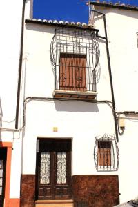 a white building with a bird cage on it at Typical Andalusian house in the center of Ronda / Casa típica andaluza en el centro de Ronda. in Ronda