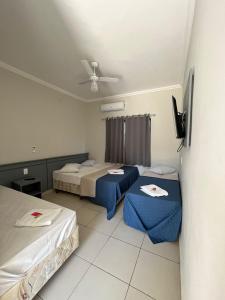a room with two beds and a ceiling at Hotel Vila dos Pescadores in Aparecida