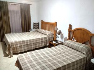 una habitación de hotel con 2 camas y una lámpara en Typical Andalusian house in the center of Ronda / Casa típica andaluza en el centro de Ronda., en Ronda
