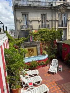 un grupo de sillas y un barco frente a un edificio en LGY G A Y Bed & Breakfast ONLY MEN en Buenos Aires