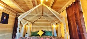 1 dormitorio con cama con dosel y almohadas verdes en RAFA Shangarh, en Sainj