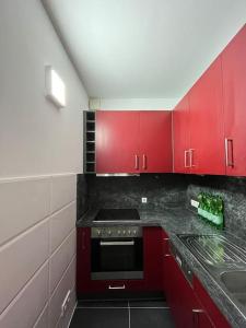 - une cuisine avec des placards rouges et une cuisinière dans l'établissement Neu Guest Place, à Quickborn
