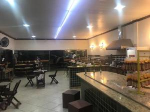 a restaurant with a bar and tables and chairs at Pousada Elefantinho in São Pedro da Aldeia