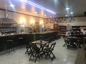 a restaurant with tables and chairs in a room at Pousada Elefantinho in São Pedro da Aldeia
