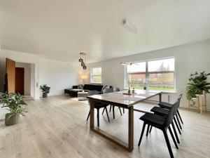 a dining room and living room with a table and chairs at Stunning & Renovated 130sqm Villa only 5 min by car from sandy beaches in Åkirkeby