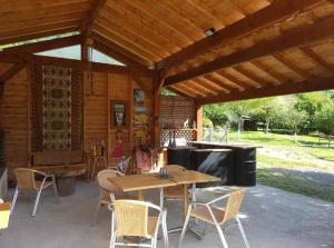 einem Holzpavillon mit einem Holztisch und Stühlen in der Unterkunft Bungalow d'une chambre avec terrasse amenagee et wifi a Sedeilhac in Franquevielle
