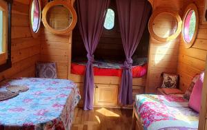 1 Schlafzimmer mit 2 Betten in einem Blockhaus in der Unterkunft Bungalow d'une chambre avec terrasse amenagee et wifi a Sedeilhac in Franquevielle
