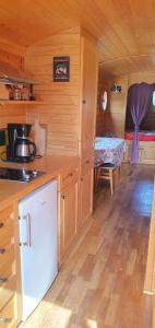 eine Küche in einer Holzhütte mit einem Tisch in der Unterkunft Bungalow d'une chambre avec terrasse amenagee et wifi a Sedeilhac in Franquevielle