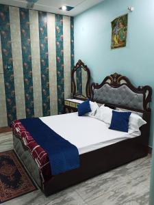 1 dormitorio con 1 cama grande con sábanas azules y blancas en ARVINDAM VILLA HOMESTAY-THE ESSENCE OF RAMA, en Ayodhya
