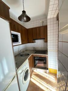 Il comprend une cuisine équipée d'un lave-linge et d'un évier. dans l'établissement Apartamento Puerta del Perdón, à Constantina