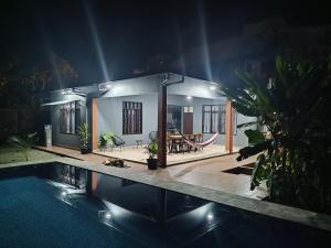 una pequeña casa con piscina por la noche en Casa de huespedes con piscina privada en Villa Tunari