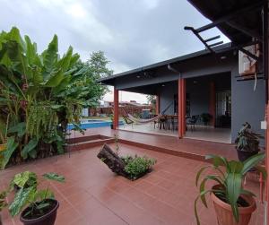 ein Haus mit einer Terrasse mit Pflanzen und einem Pool in der Unterkunft Casa de huespedes con piscina privada in Villa Tunari