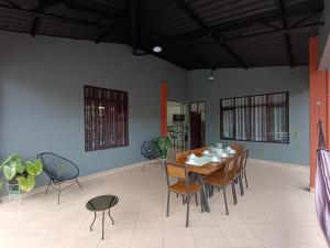 Casa de huespedes con piscina privada في فيلا توناري: غرفة طعام مع طاولة وكراسي خشبية