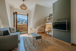 a living room with a couch and a tv at Lipki Park Zakopane in Zakopane