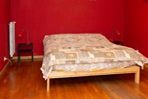 uma cama num quarto com uma parede vermelha em Dream10 em Parabiago