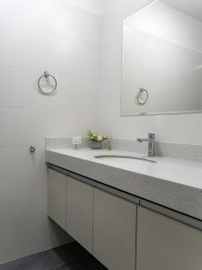 a white bathroom with a sink and a mirror at 2BR in Center of Miraflores La Paz in Lima