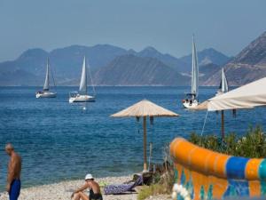 a beach with boats in the water and a group of people at Mare - Mare B in Patra