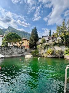 a river with green water and buildings in the background at Rossi Lake Family in Oliveto Lario