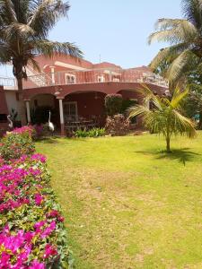 une maison avec un jardin et des fleurs devant elle dans l'établissement Villa Savana, à La Somone
