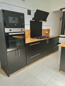 a kitchen with black cabinets and a stove at Villa Savana in Somone
